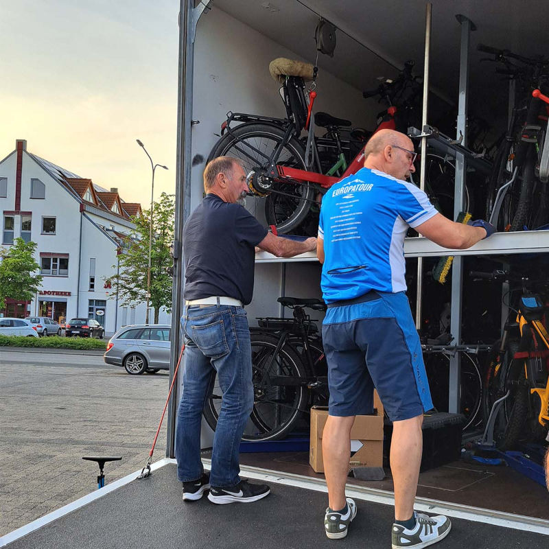 Mitarbeiter verladen Gepäck und Ausrüstung am Reisebus bei einer Bus Radreise mit Philippi Reisen