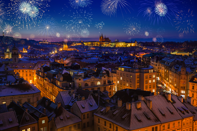 Prague Castle with snowy rooftops during late christmas sunset with blue sky and glowing street lights
