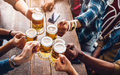 Eine Gruppe von Leuten genießt und stößt mit einem Bier in der Brauereigaststätte an.