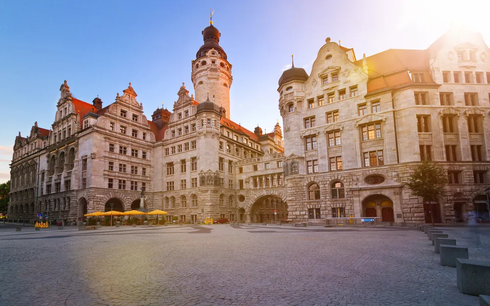 Historische Gebäude mit Türmen und Sonnenlicht beleuchtet.