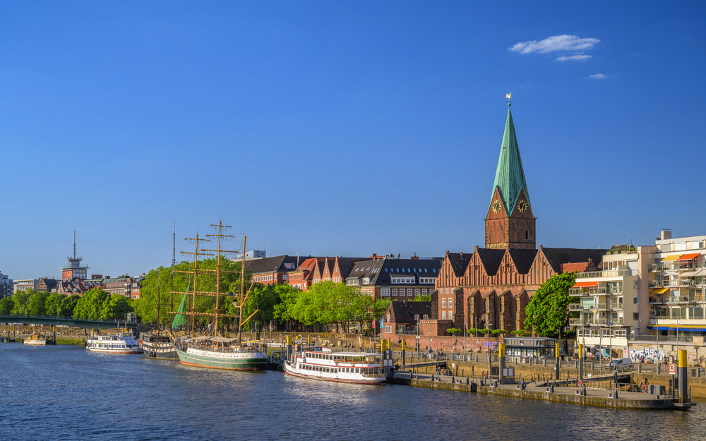 Altstadt von Bremen mit Weserufer und historischer Kirche bei klarem Himmel