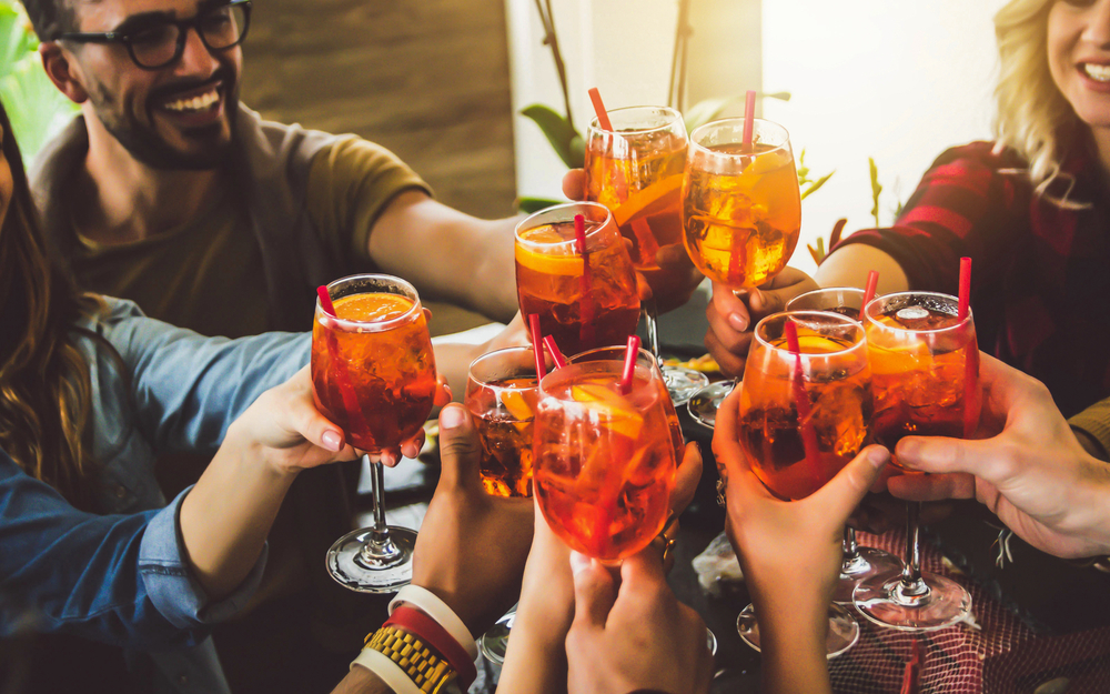 fröhliche Freunde stoßen in einem Bar-Restaurant mit ihren Gläsern an 