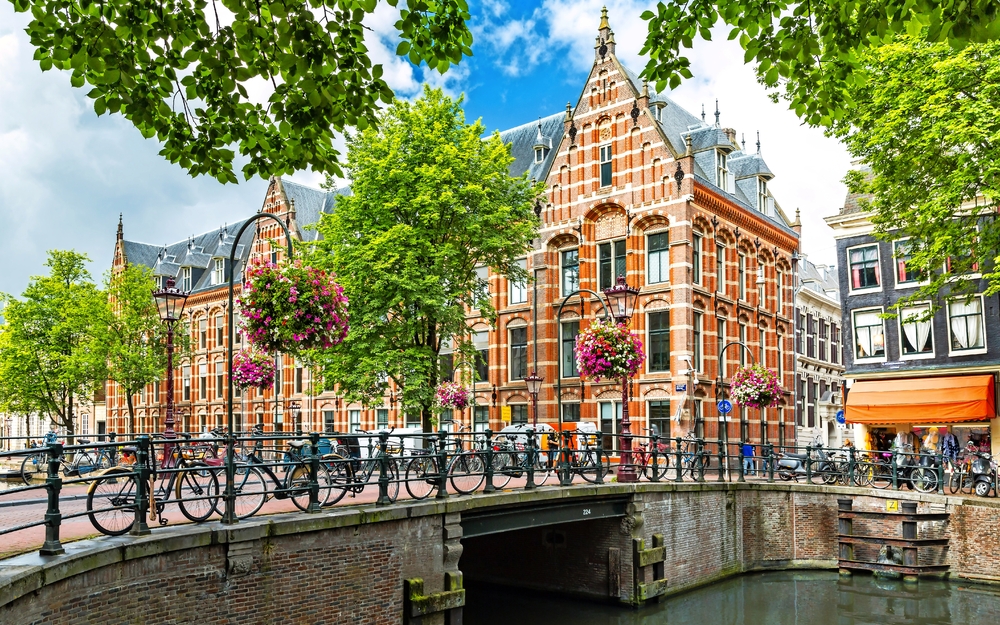 Backstein-Gebäude und Fahrräder an einer Brücke in Amsterdam.