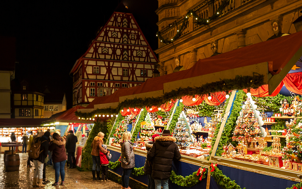 Weihnachtsmarkt in Rothenburg ob der Tauber bei Nacht mit beleuchteten Ständen.
