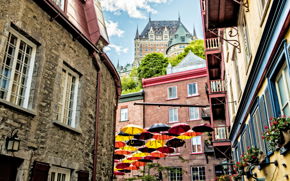 Regenschirme in der Rue Petit Champlain mit Château Frontenac im Hintergrund in Québec, Kanada