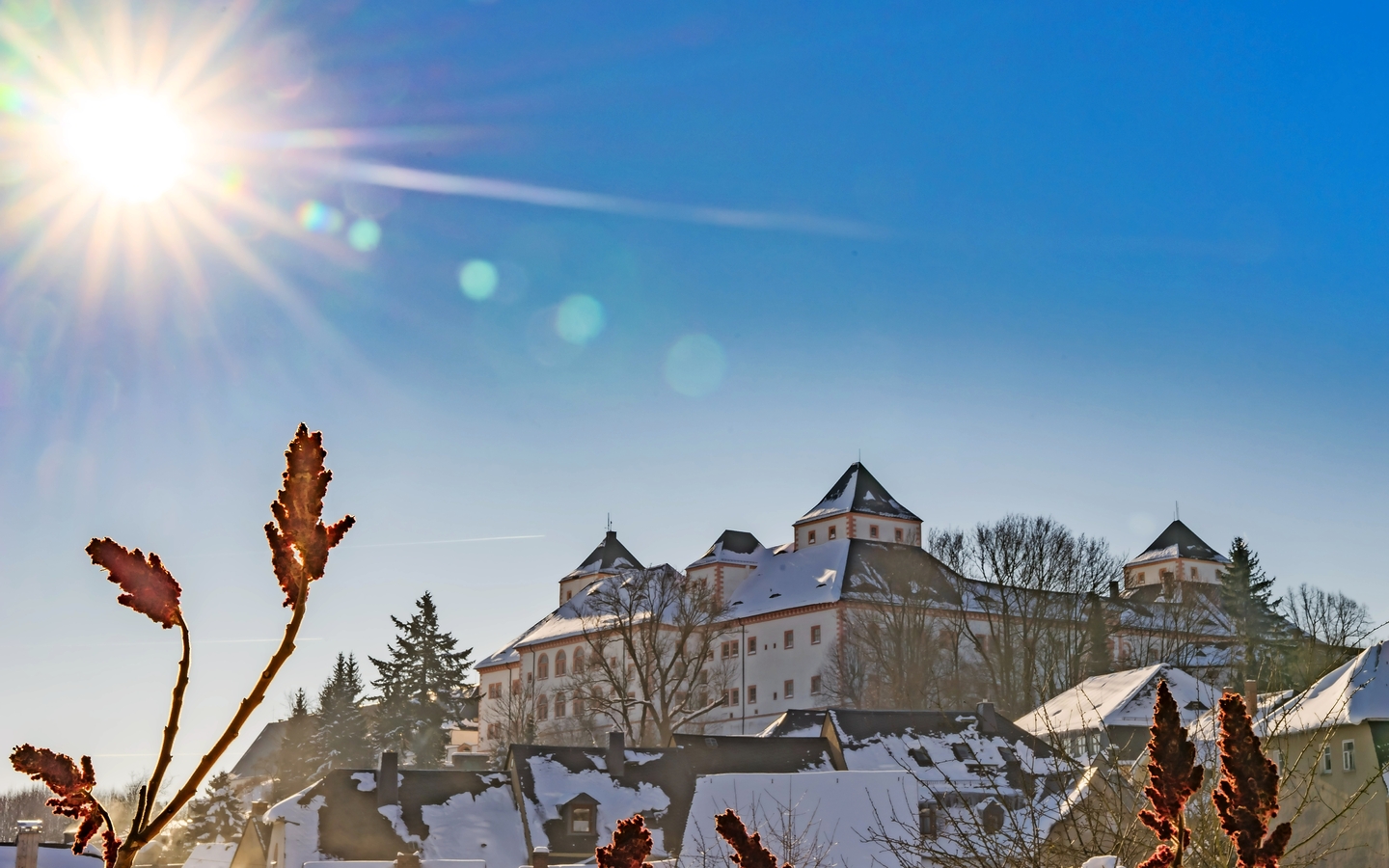 das Jagdschloss Augustusburg, im Winter bei weißem Schnee und blauem Himmel